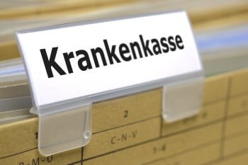 Schild mit Aufschrift "Krankenkasse" klemmt an Ordner