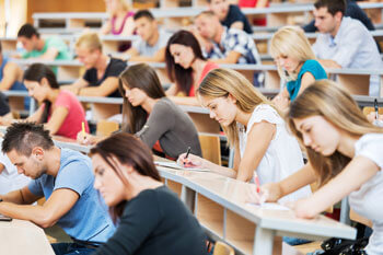 Studenten im Hörsaal machen sich Notizen während einer Vorlesung.