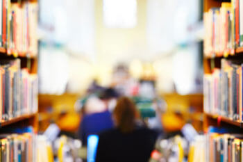 Eine Frau arbeitet in einer Bibliothek.