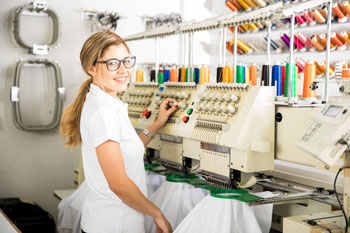 Textil Beruf Eine Frau bedient eine Maschine in einer Textilfabrik.
