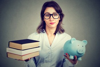 Studentin hält Bücher und Sparschwein